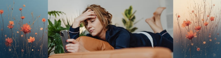 Woman lying on a sofa looking tired while checking her phone, framed by soft floral imagery on both sides.